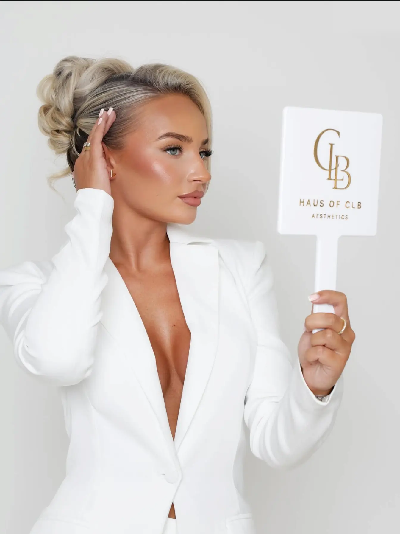 Nurse Charlotte holding the Haus of CLB logo